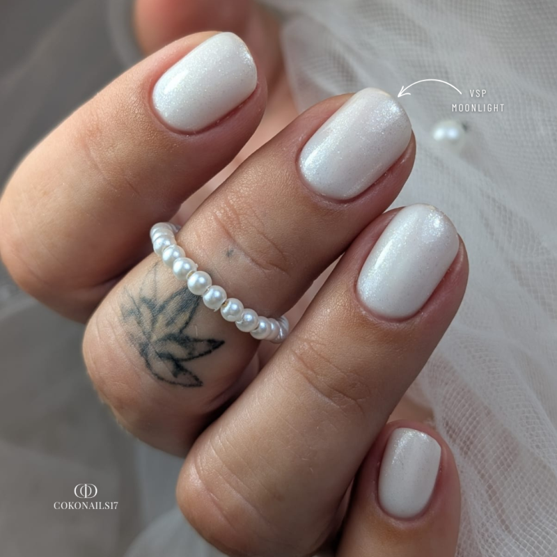 Pose d'ongles avec le vernis semi-permanent Moonlight, blanc laiteux pailleté