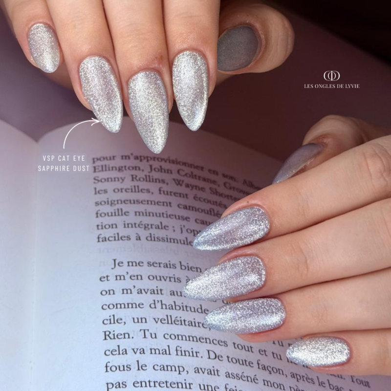 Pose d'ongles avec le vernis semi permanent Sapphire Dust Cat Eye, pastel bleu réflective
