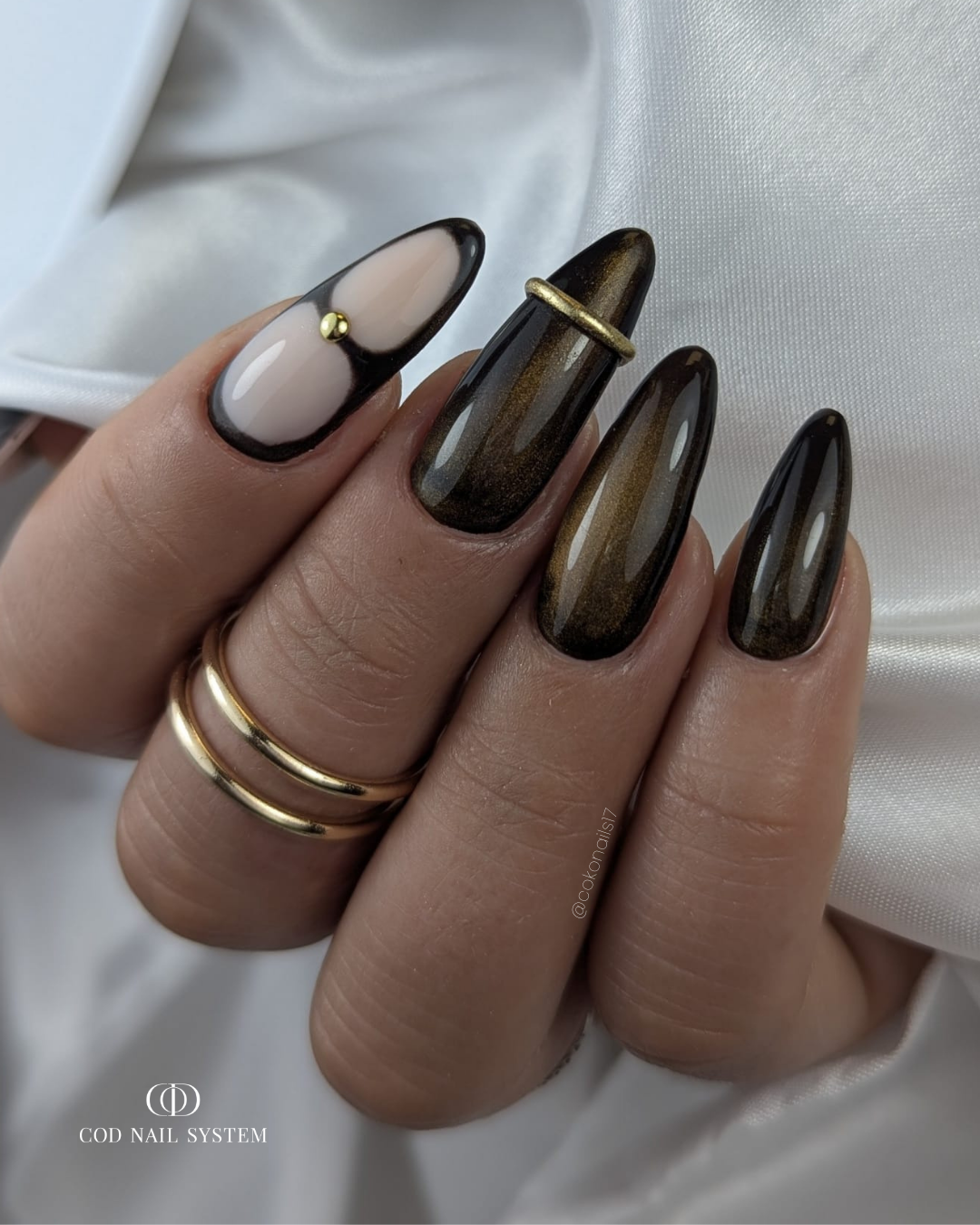 Pose d'ongles amandes cat eye avec bague 3D dorée Pose d'ongles en amandes vert cat eyes avec french et bague d'ongles en 3d dorée