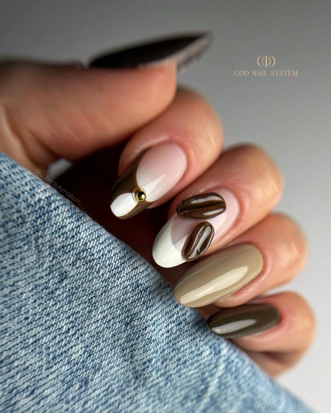 Pose d'ongles en amandes marron avec café en 3d Pose d'ongles en amandes marron avec french et grains de café en 3d