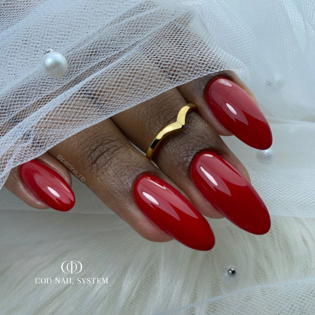 Pose d'ongles en amandes rouge avec finition ultra glossy