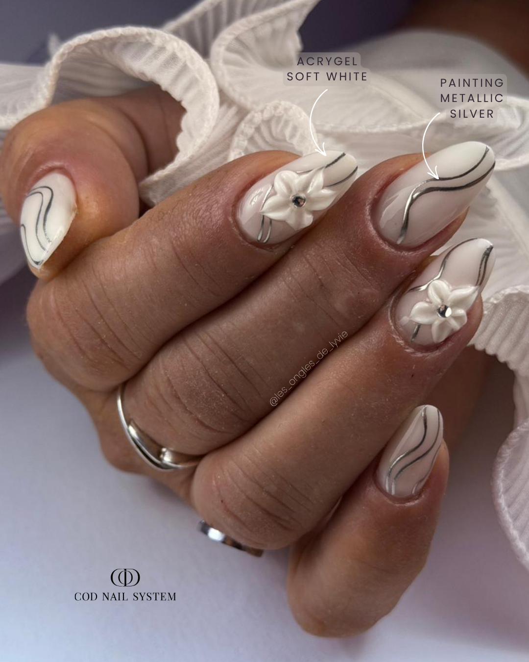Ongles milky avec nail art métallique et 3D Pose d'ongles en amandes milky avec nail art métallique argentés et fleurs 3D