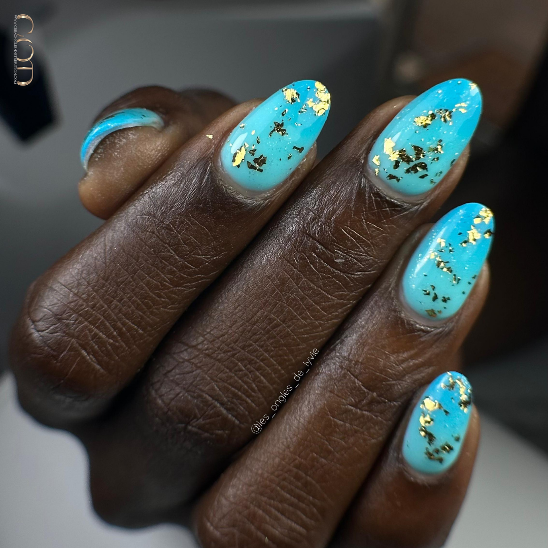 Pose d'ongles amandes bleu avec flakes dorés