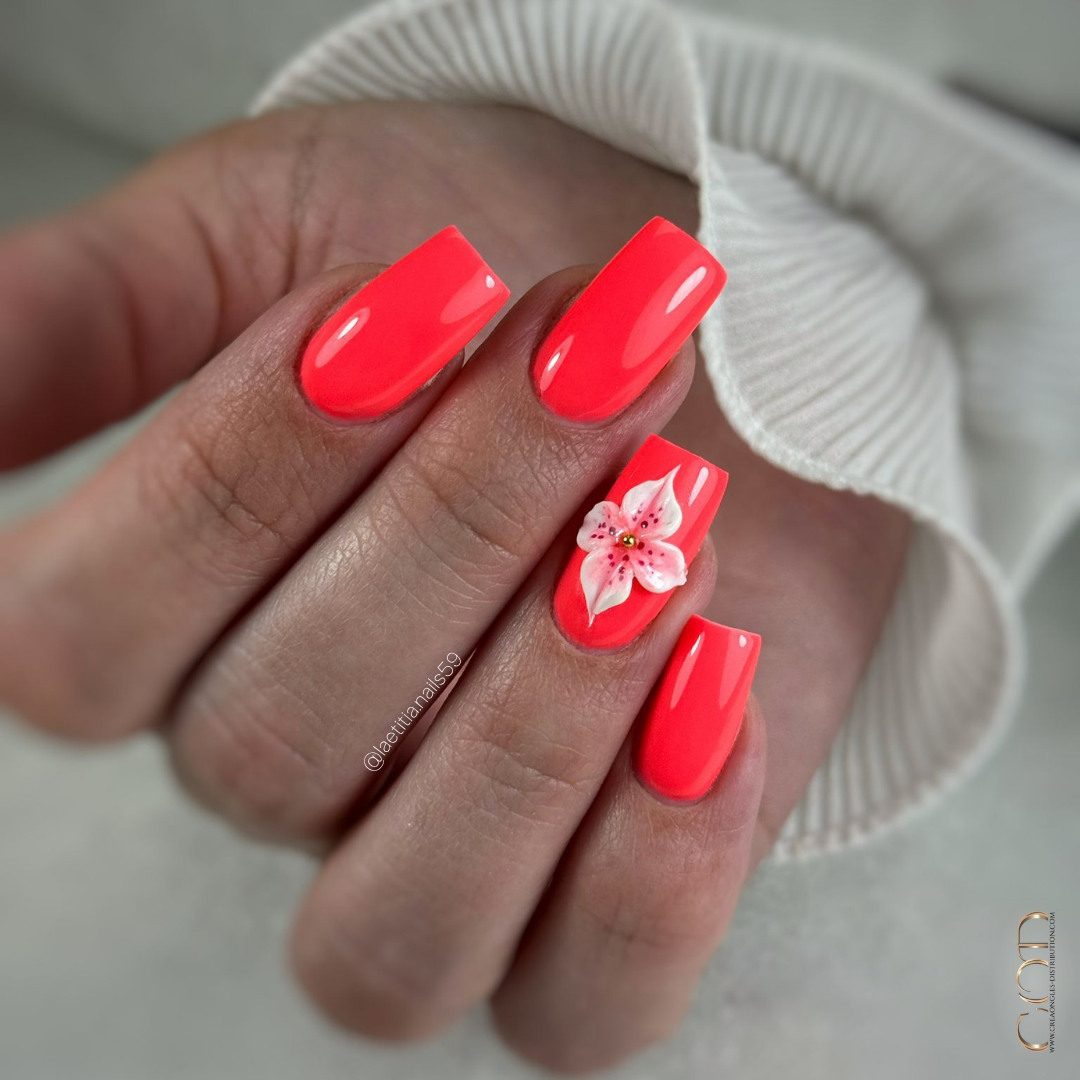 Pose d'ongles carrée néon corail avec fleur 3D blanche