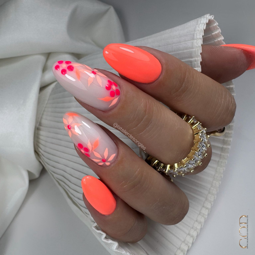 Pose d'ongles amandes néon corail avec nail art fleurs sur blanc laiteux