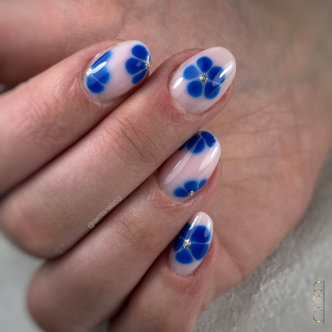 Pose d'ongles ovale avec fleurs blossom bleu