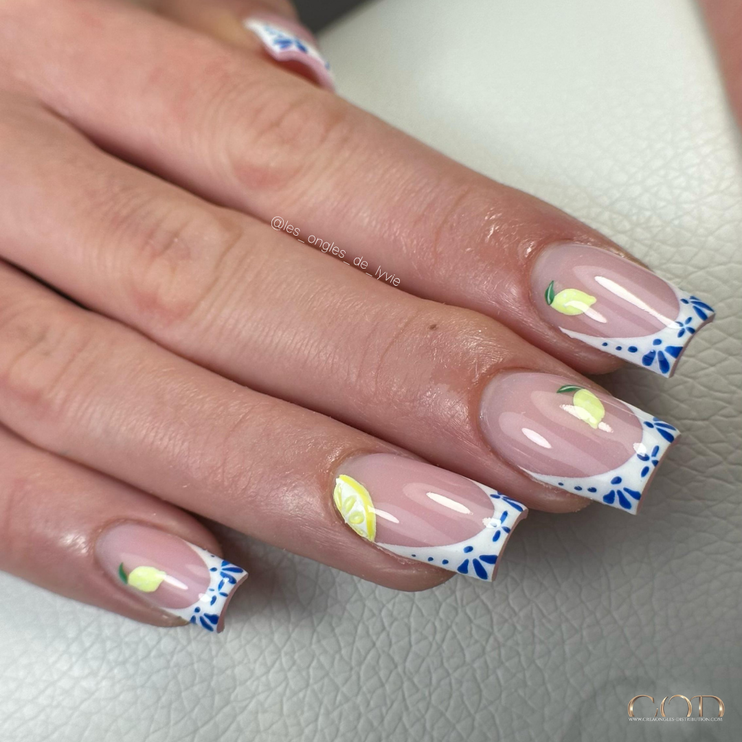 Pose d'ongles carrée avec french céramique et nail art citron 3D