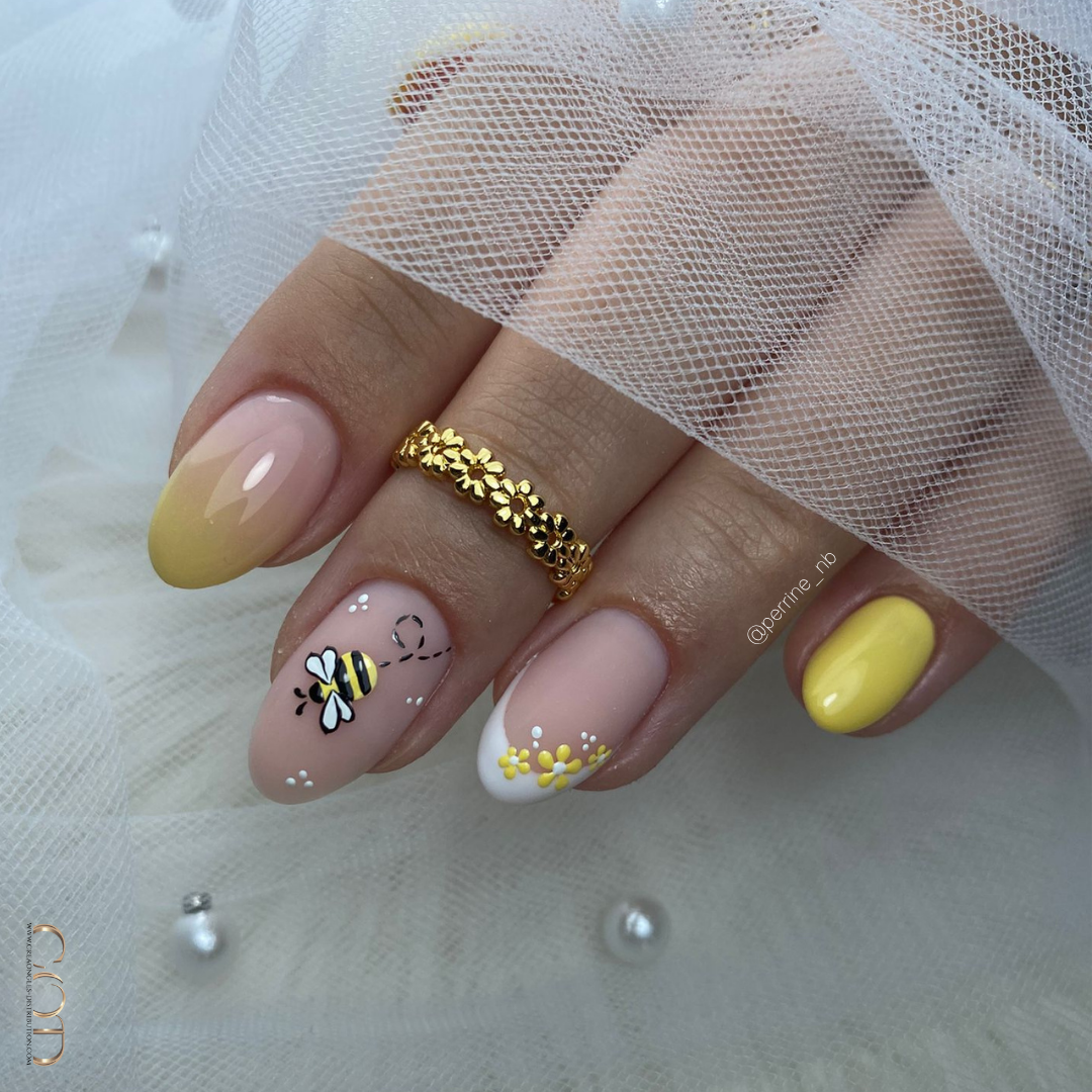 Pose d'ongles amandes jaune pastel avec nail art abeilles et fleurs