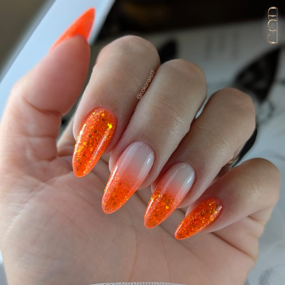 Pose d'ongles amandes néon orange pailletée avec babyglitter