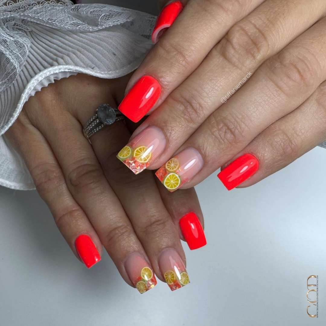 Pose d'ongles carrée néon corail avec incrustation de citrons