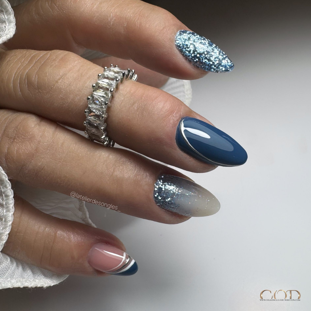 Pose d'ongles en amandes bleu pétrole avec incrustation de paillettes, cutiglitter et nail art argenté métallique