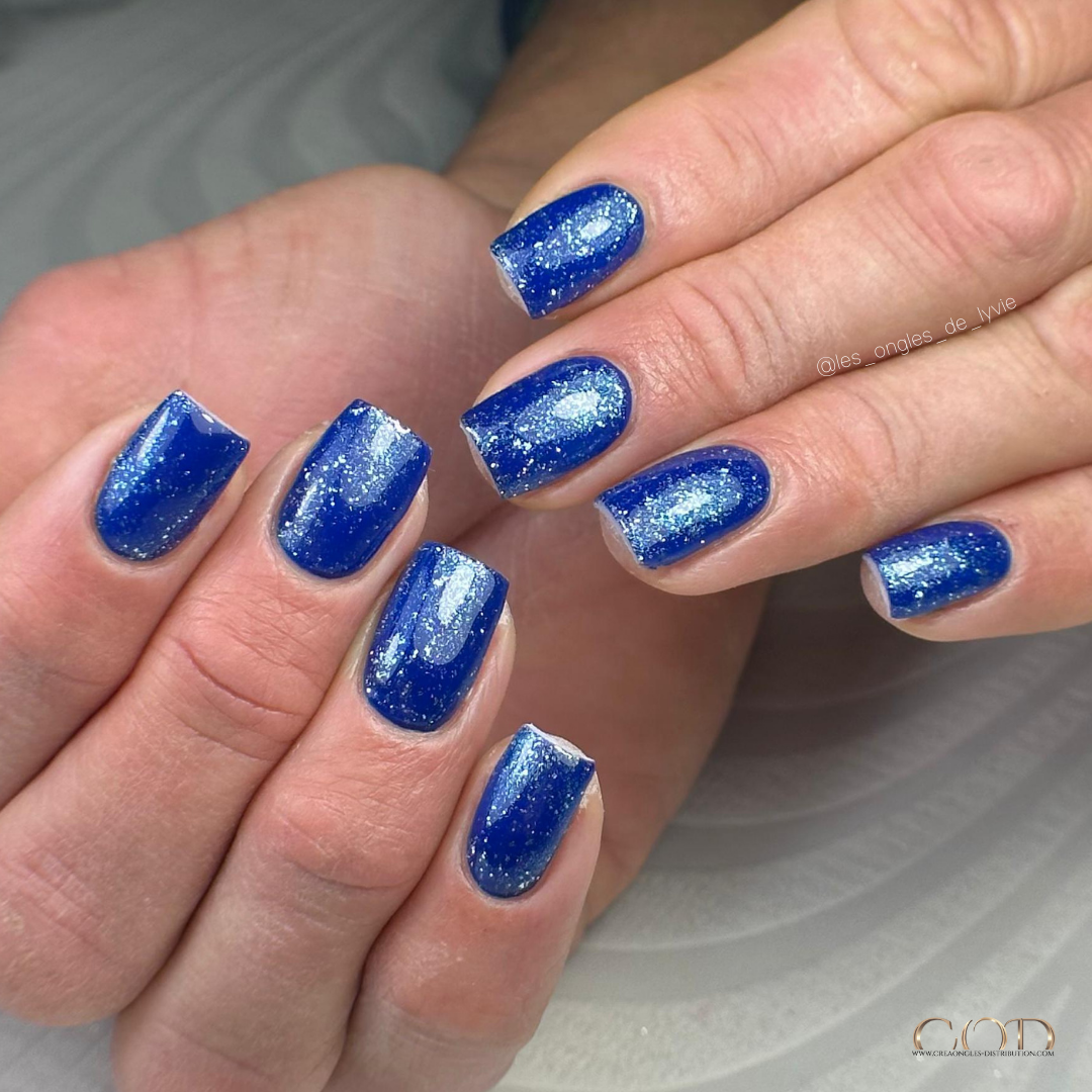 Pose d'ongles bleu électrique avec finition flakes aurora