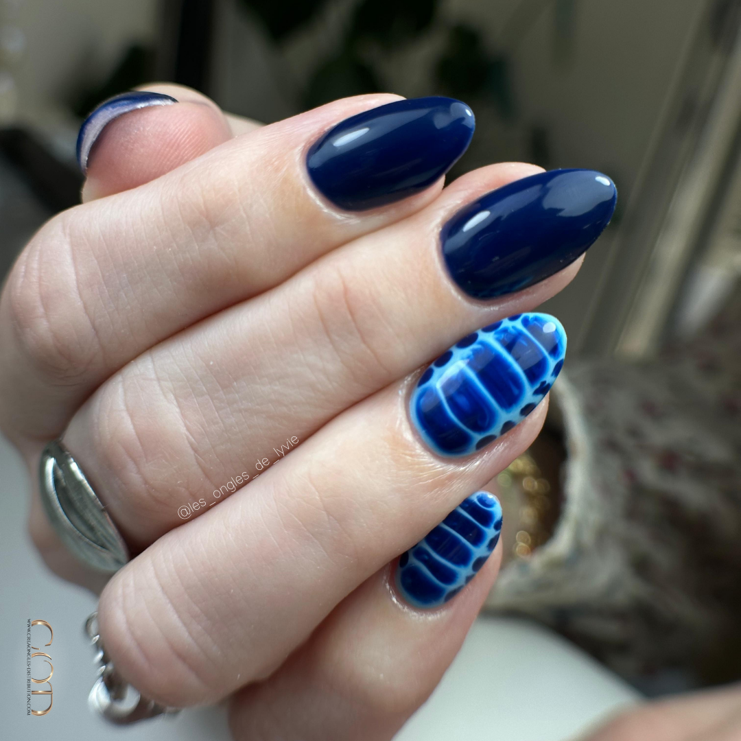 Pose d'ongles en amandes bleu nuit avec nail art blossom