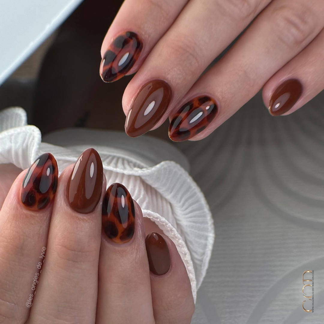 Pose d'ongles en amandes courtes marron avec nail art tortoise