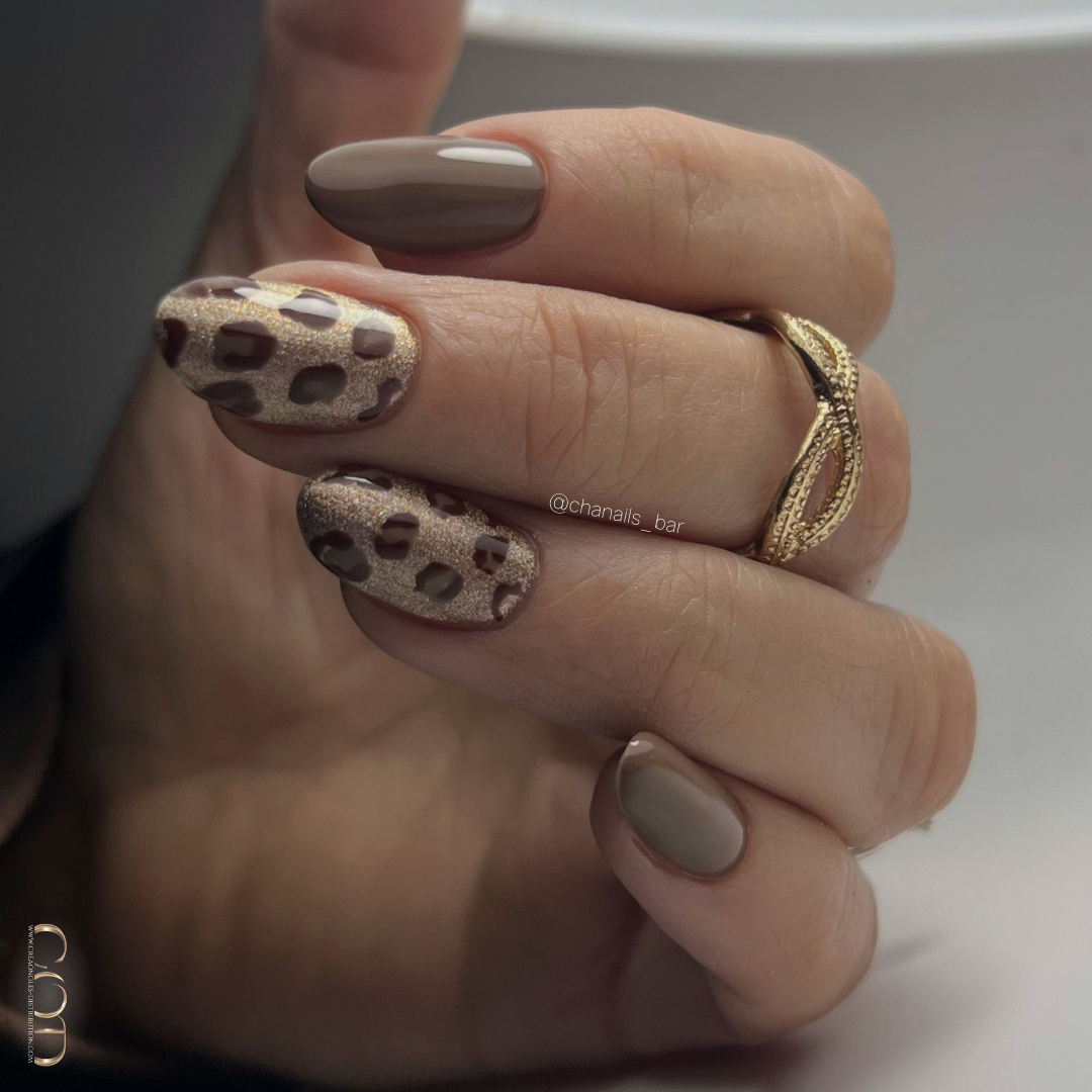 Pose d'ongles en amandes courtes marron et dorées avec nail art léopard