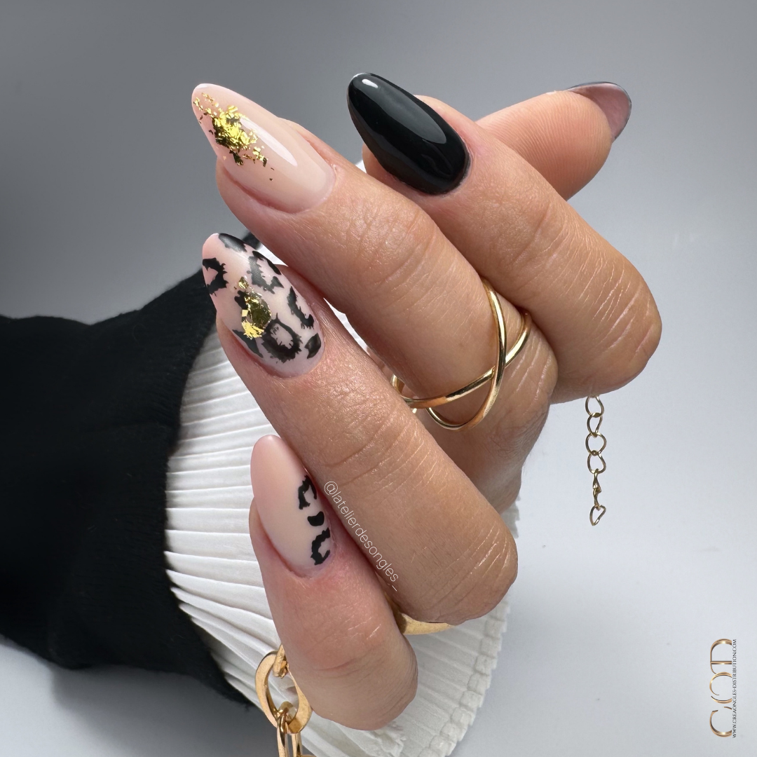 Pose d'ongles en amandes noires avec nail art léopard et flakes or