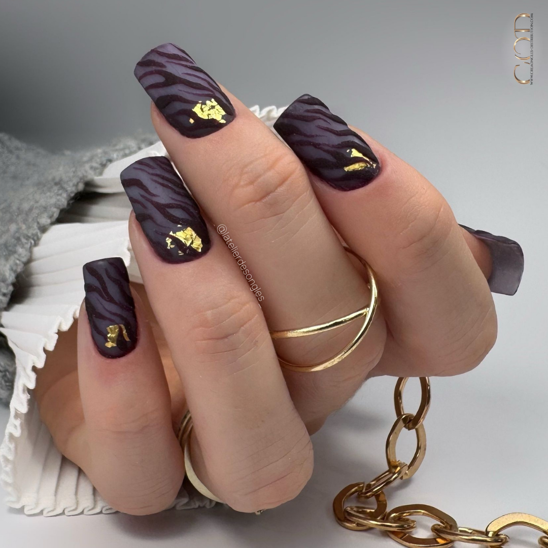 Pose d'ongles carrés longs violets matt avec nail art zébré en effet velours et flakes or