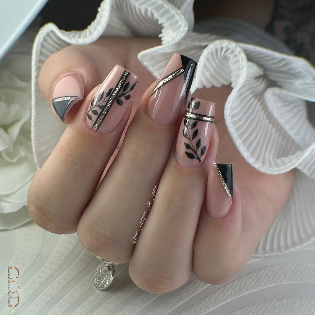 Pose d'ongles carrés longs nude et noirs avec nail art feuillage et paillettes dorées