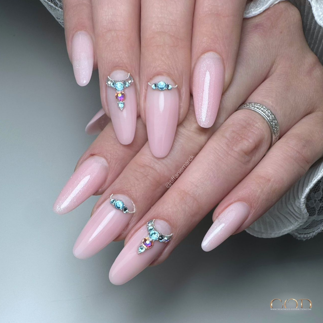 Pose d'ongles en amandes longues roses avec bijoux en strass
