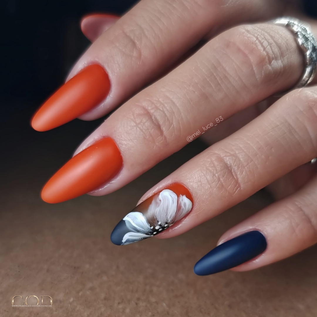 Pose d'ongles amandes matt longues orange rouille et bleu nuit avec dégradé et nail art fleur