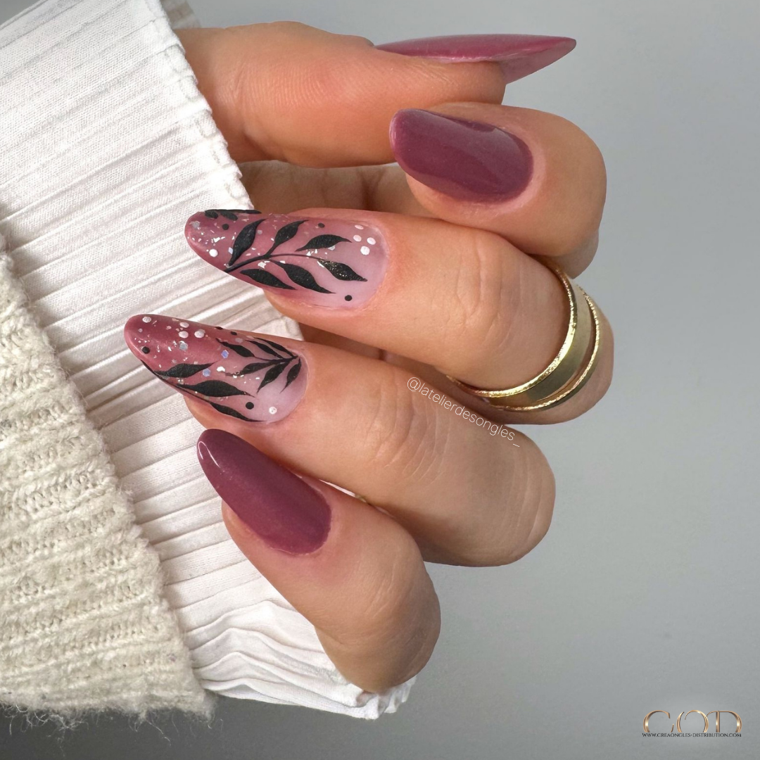 Pose d'ongles en amandes bordeaux avec nail art feuillage matt