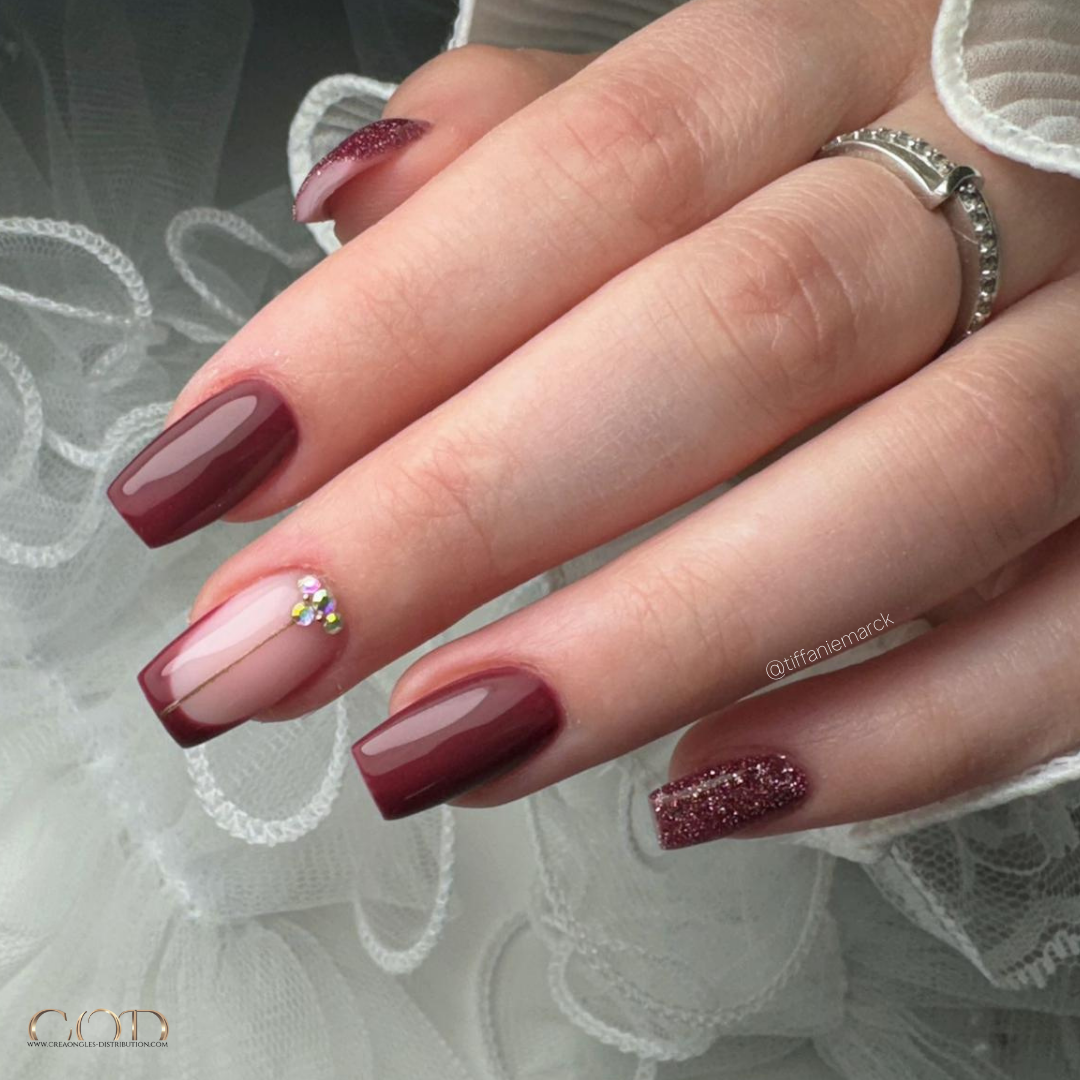 Pose d'ongles carrée medium bordeaux avec french, paillettes et strass