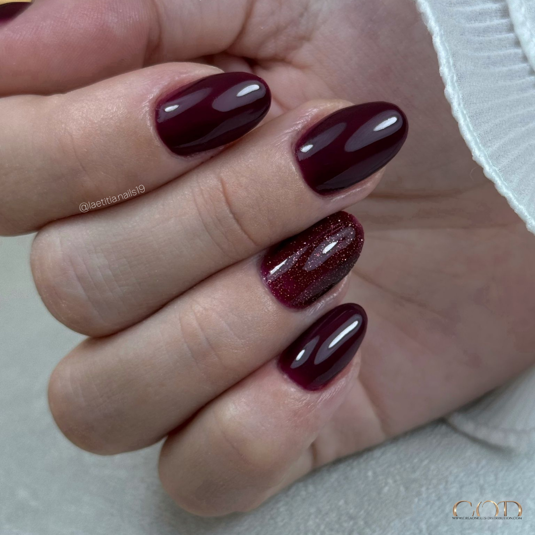 Pose d'ongles ovales courts bordeaux et reflective