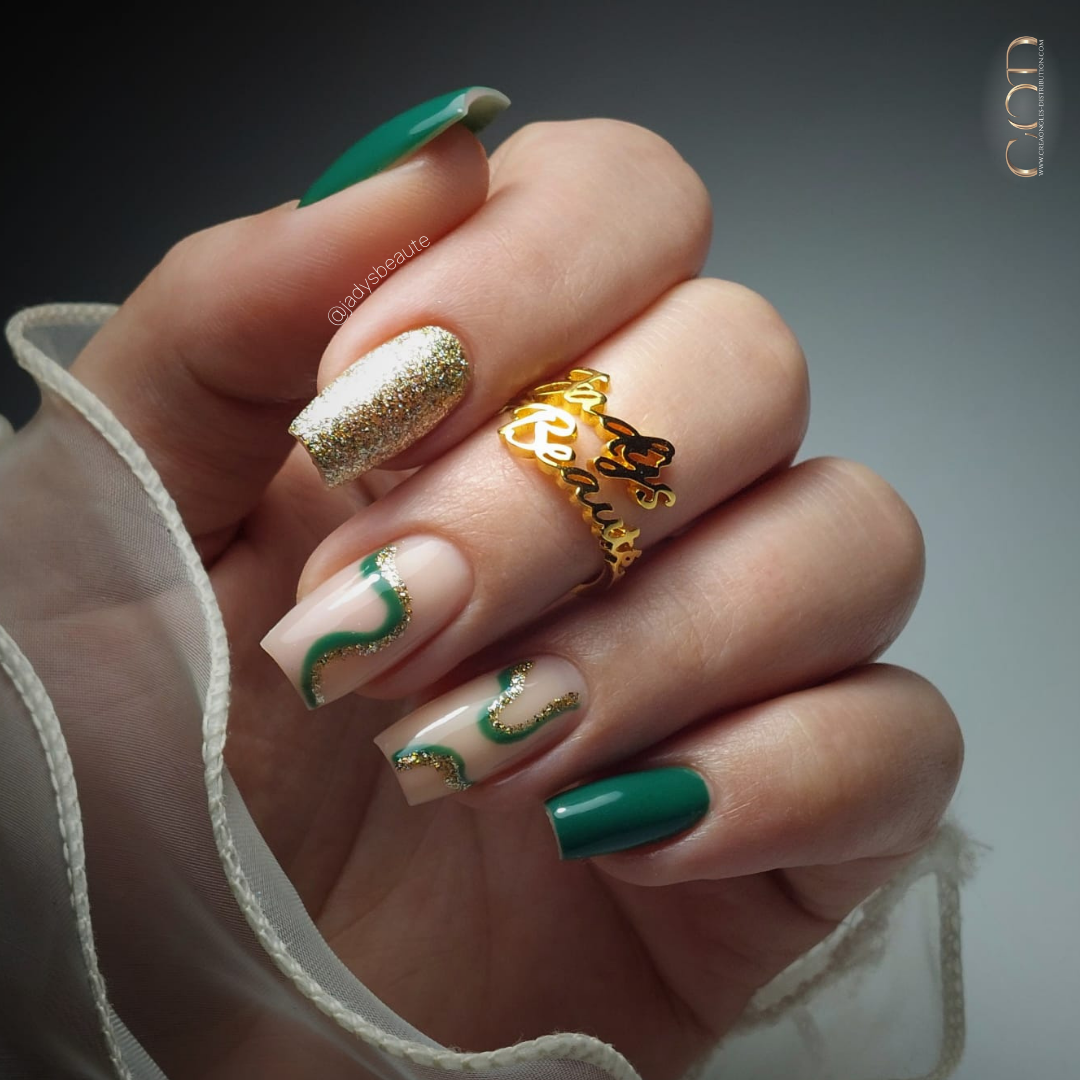 Pose d'ongles carrés longs nude beige et vert sapin avec nail art et paillettes dorées