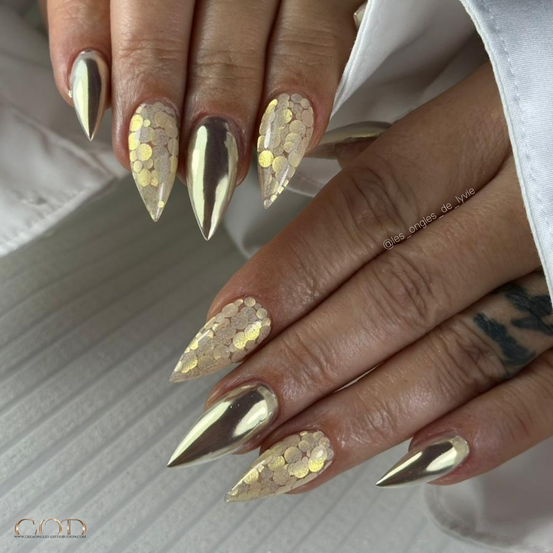 Pose d'ongles en stilettos avec chrome doré et incrustations de paillettes Pose stilettos dorée
