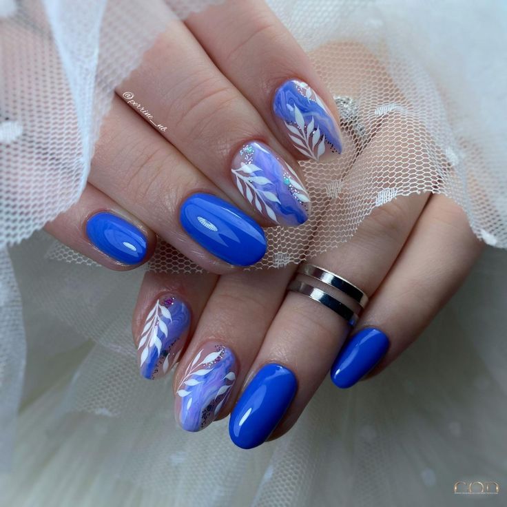 Pose ongles bleu électrique avec nail art marbre et feuillage