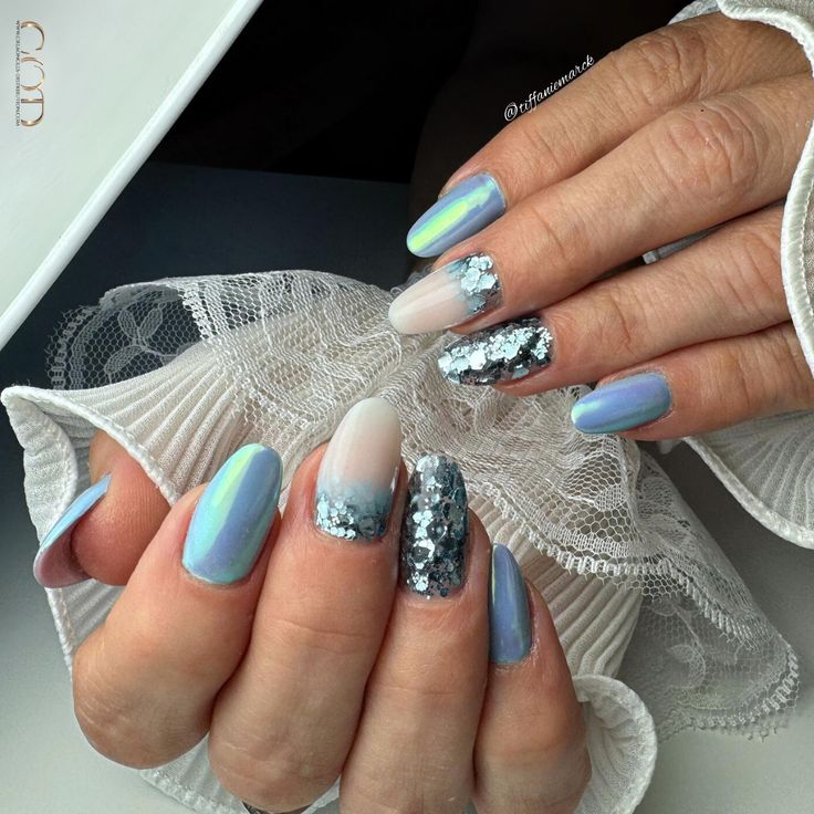 Ongles ovales bleu pastel avec incrustation de paillettes, cutiglitter et pigment effet aurora