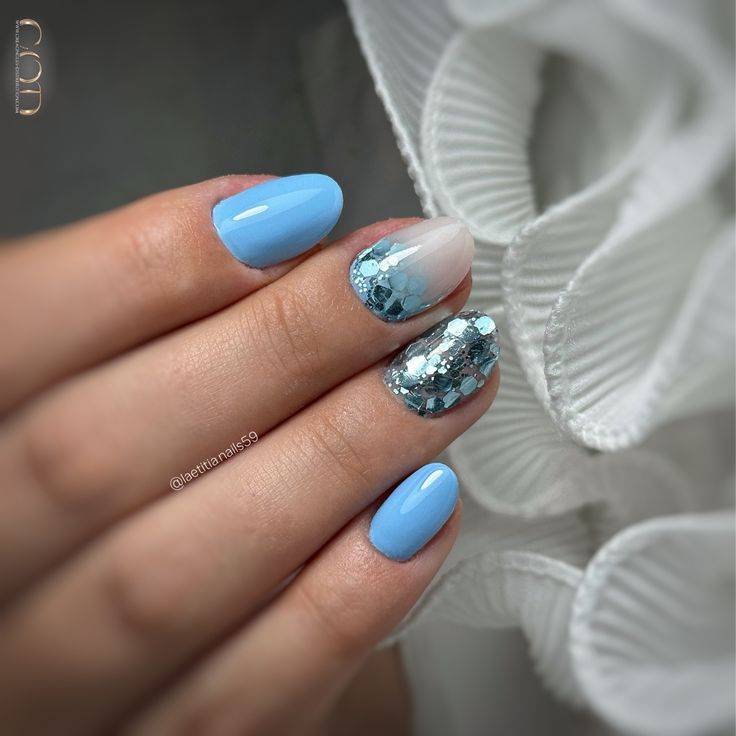 Ongles ovales courts bleu pastel avec incrustation de paillettes et cutiglitter blanc laiteux