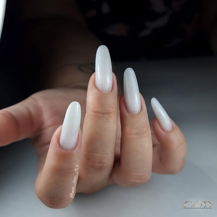 Pose d'ongles ovale longs avec gel blanc laiteux à paillettes