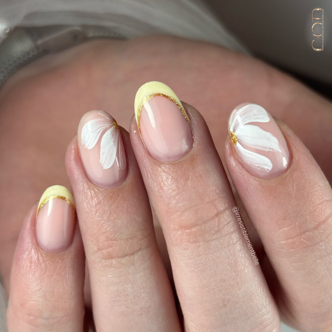 Pose d'ongles ovales avec french jaune pastel et fleurs blanches