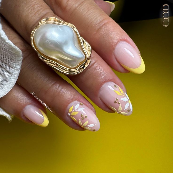 Pose d'ongles en amande avec french jaune et nail art fleurs