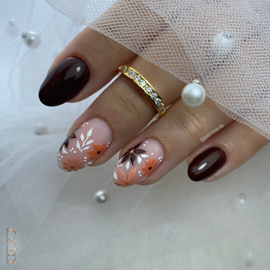 Pose d'ongles ovales marron avec nail art fleurs sur base matt
