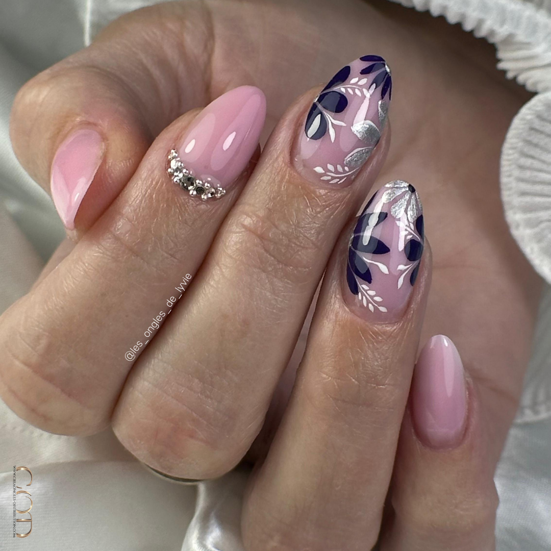 Pose d'ongles ovales rose avec nail art floral violet et argenté
