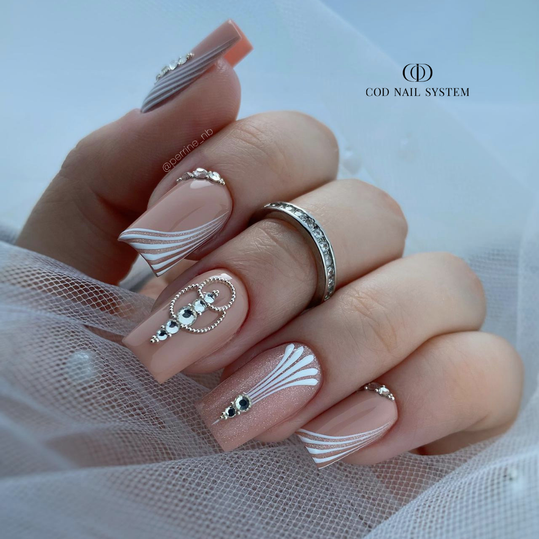 Ongles nude beige avec nail art et strass Pose d'ongles carrée nude beige avec nail art et bijoux en strass