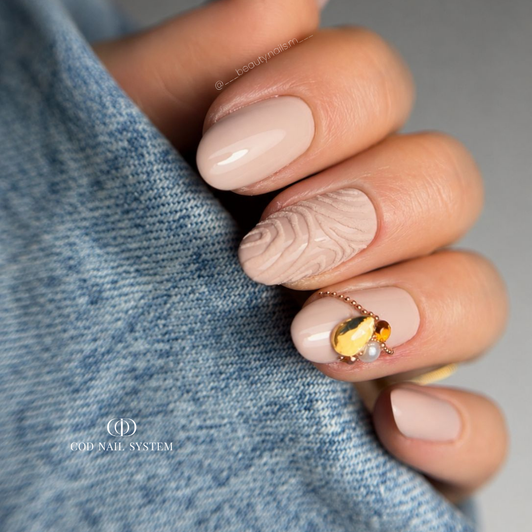 Ongles en amandes nude beige nail art effet velours Pose d'ongles en amandes nude beige avec nail art effet velours et bijoux d'ongles en strass