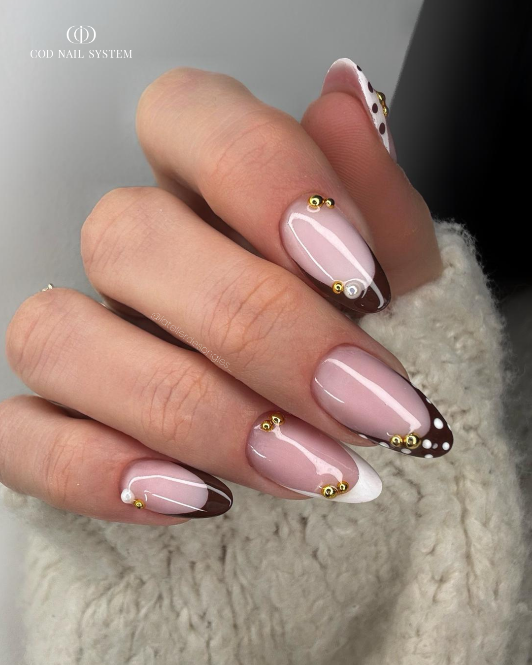 Pose d'ongles en amandes marron et blanche avec polka dots et strass dorés
