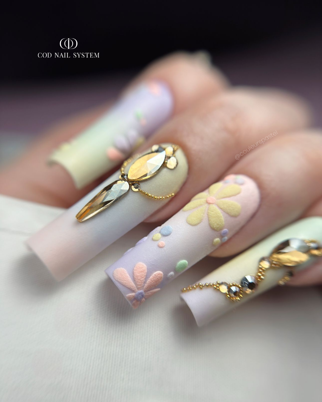 Pose d'ongles carrés longs avec dégradés pastels matt, fleurs en effet velours et bijoux en strass
