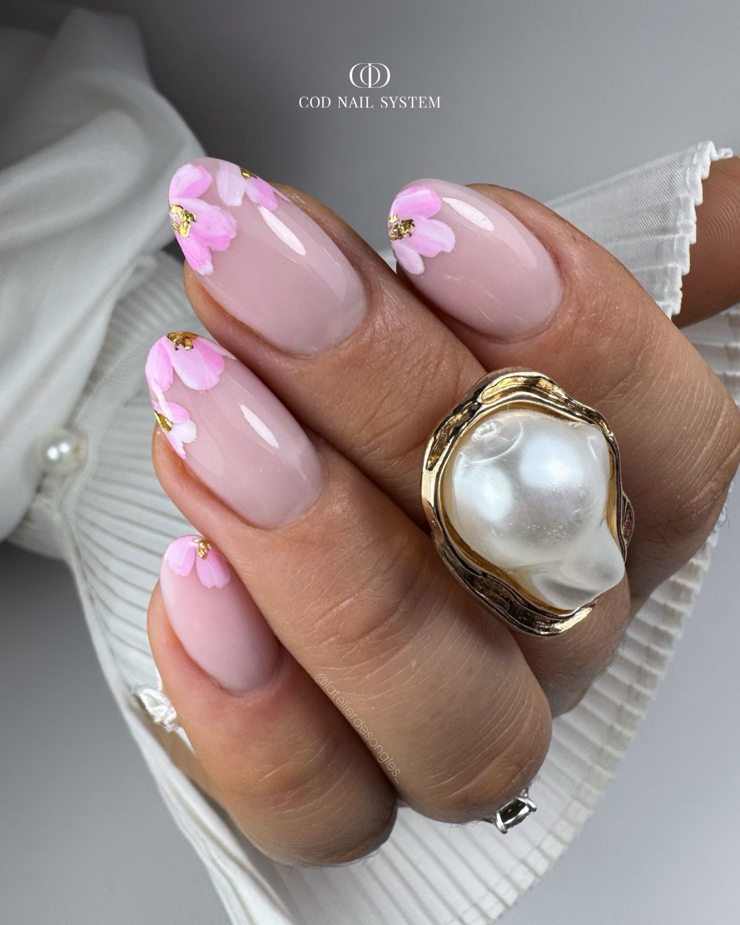 Pose d'ongles en amandes avec nail art fleurs roses pastels
