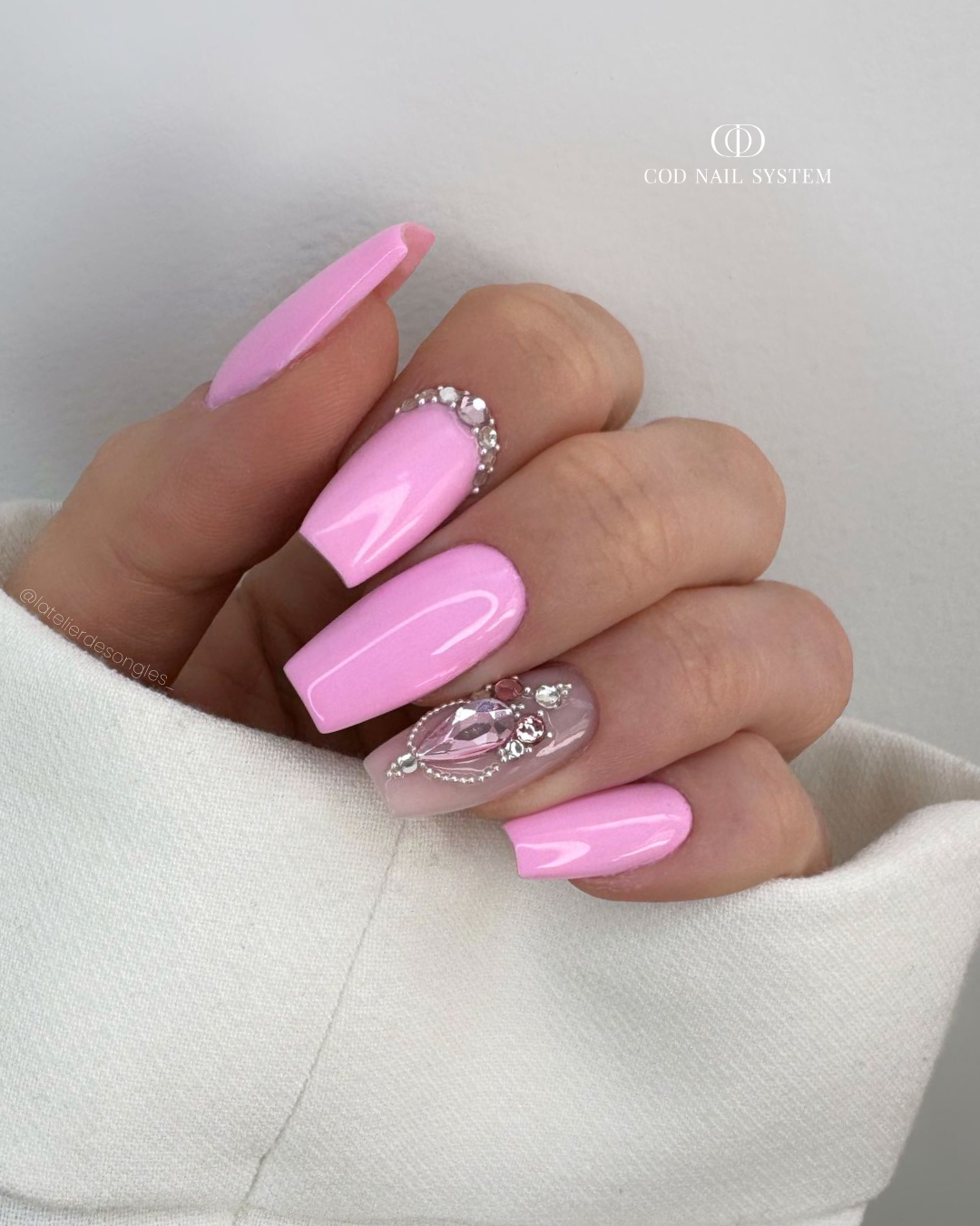 Pose d'ongles coffin rose paqtel avec bijoux en strass