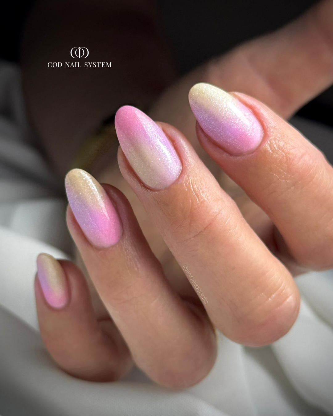 Pose d'ongles en amandes avec dégradés de couleurs pastels et finition pailletée