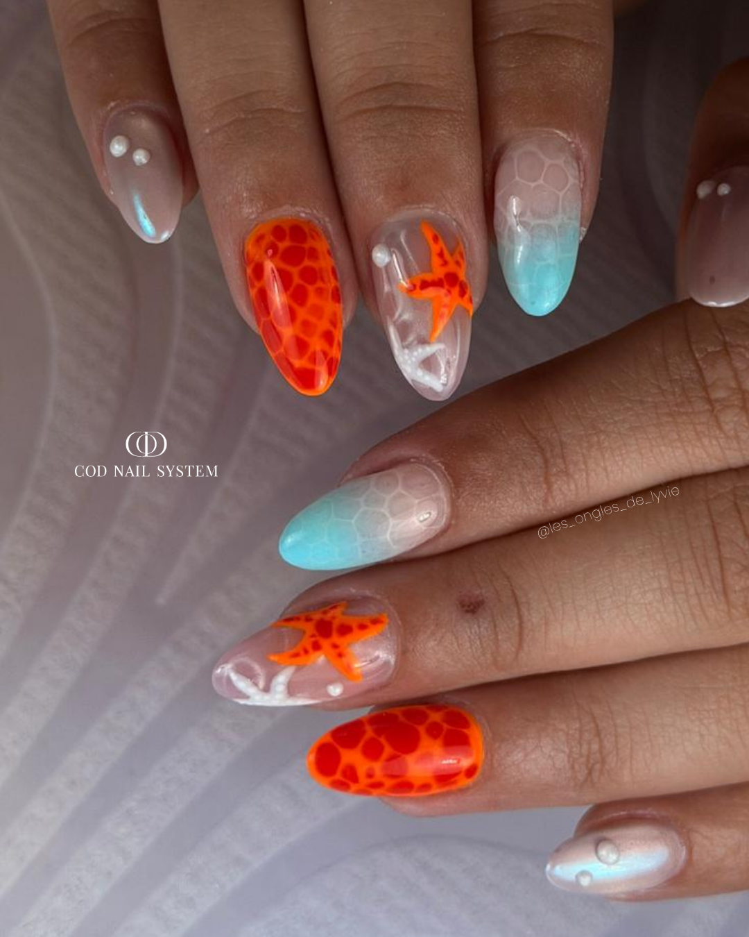 Pose d'ongles en amandes néon avec nail art blooming et étoiles de mer