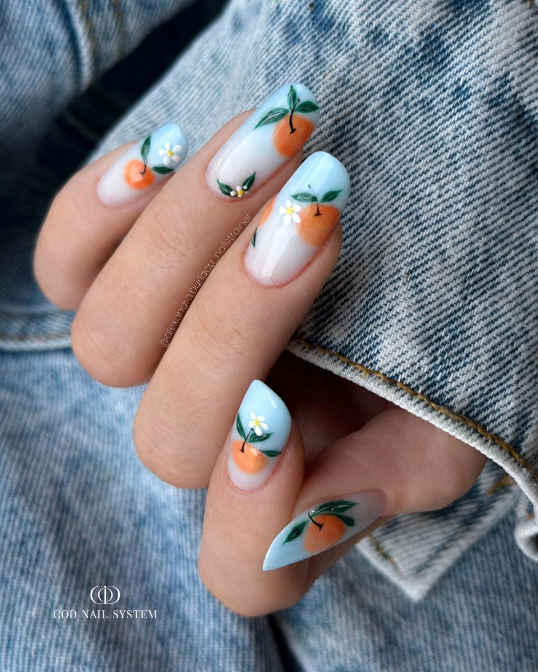Pose d'ongles en amandes avec babycolor bleu pastel et nail art clémentines