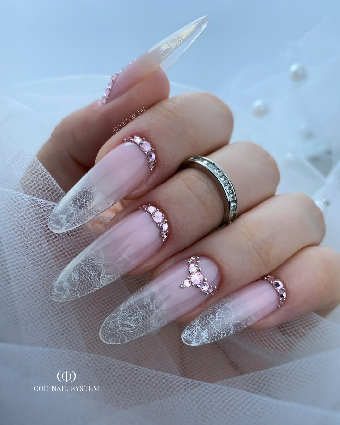 Pose d'ongles en amandes nude rosé avec babyboomer clear effet dentelle et bijoux en strass