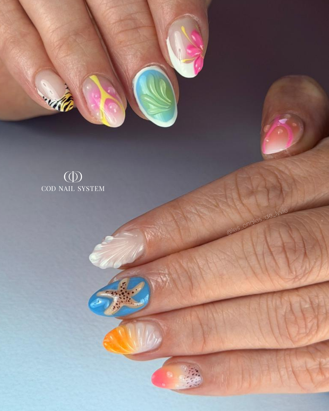 Pose d'ongles en amandes colorés avec nail art d'été en 3D