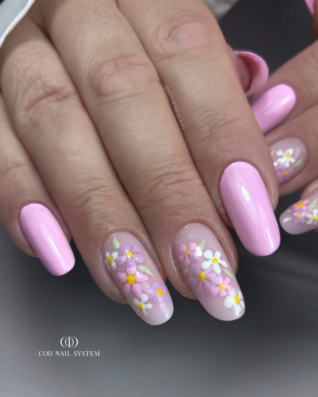 Pose d'ongles en amandes rose pastel avec nail art fleurs