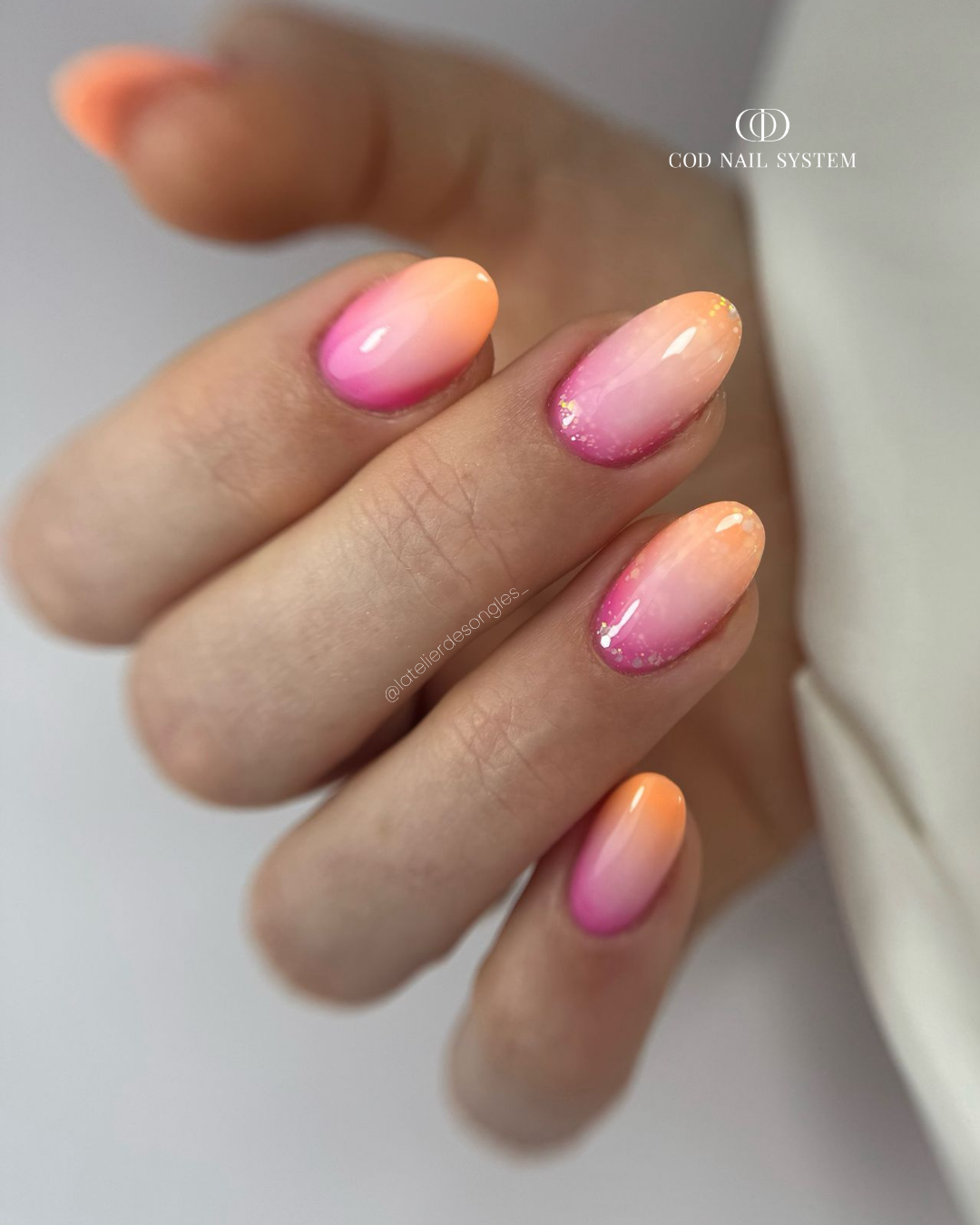 Pose d'ongles en amandes avec dégradé rose et orange néon milky white